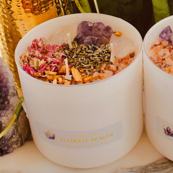 Ultimate Healer Crystal Candle in a sleek white jar container, adorned with rose quartz and amethyst stones, designed to promote purity, peace, and love. Also empowered with lavender, rose, palo santo, and more. Bath and Body Works Pure Paradise replica scent. Available in three sizes: 1 wick/6oz, 2 wicks/10oz, and 3 wicks/16oz.