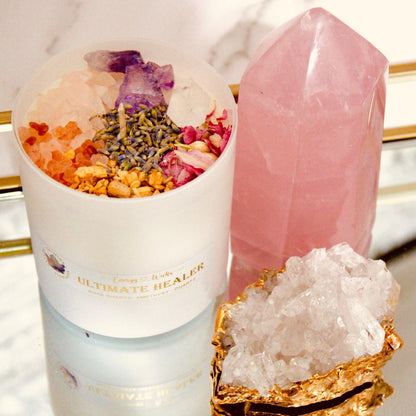 Ultimate Healer Crystal Candle in a sleek white jar container, adorned with rose quartz and amethyst stones, designed to promote purity, peace, and love. Also empowered with lavender, rose, palo santo, and more. Bath and Body Works Pure Paradise replica scent. Available in three sizes: 1 wick/6oz, 2 wicks/10oz, and 3 wicks/16oz. 